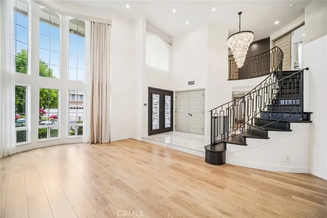 an empty room with wooden floor a fireplace and a chandelier