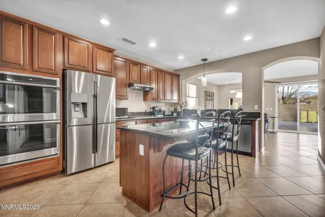 a kitchen with stainless steel appliances granite countertop a refrigerator and a stove top oven