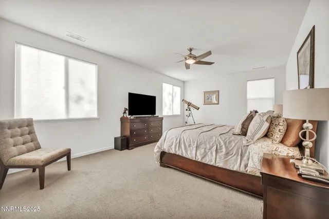 a spacious bedroom with a bed and a television