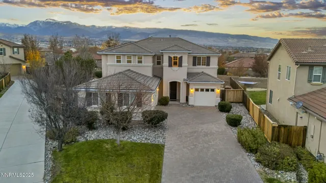 a view of a white house next to a yard with potted plants