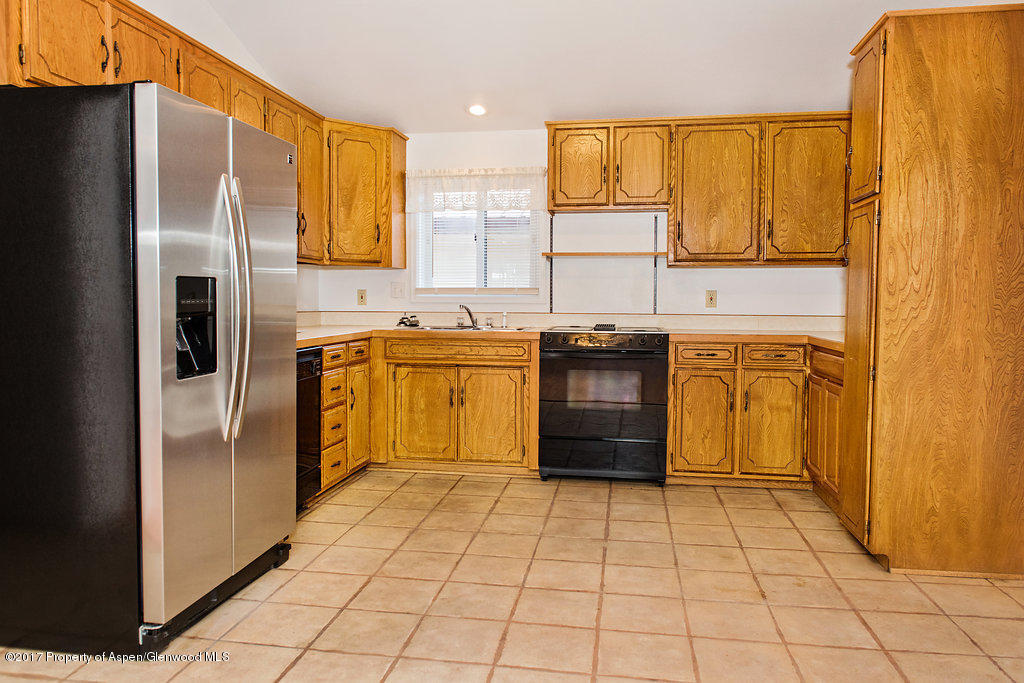 554 Jarrad Avenue Rifle, CO 81650 - Photo 7 of 21 a kitchen with stainless steel appliances granite countertop a refrigerator a sink dishwasher and a stove with wooden cabinets