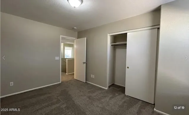 an empty room with closet and a window