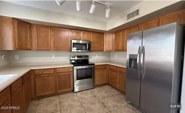 a kitchen with stainless steel appliances granite countertop a refrigerator a stove a sink and dishwasher