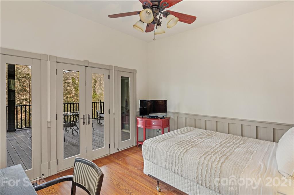 471 Chestnut Hill Loop Road Gerton, NC 28735 - Photo 21 of 45 a bedroom with a large bed and a chandelier