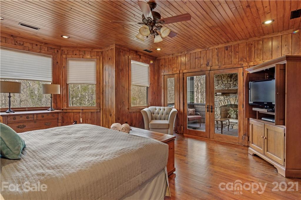 471 Chestnut Hill Loop Road Gerton, NC 28735 - Photo 31 of 45 a bedroom with a large bed a flat tv screen and large windows