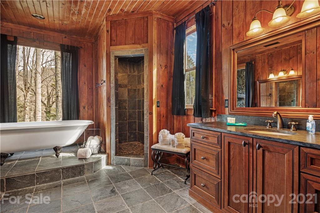 471 Chestnut Hill Loop Road Gerton, NC 28735 - Photo 33 of 45 a bathroom with a sink a mirror and a bathtub