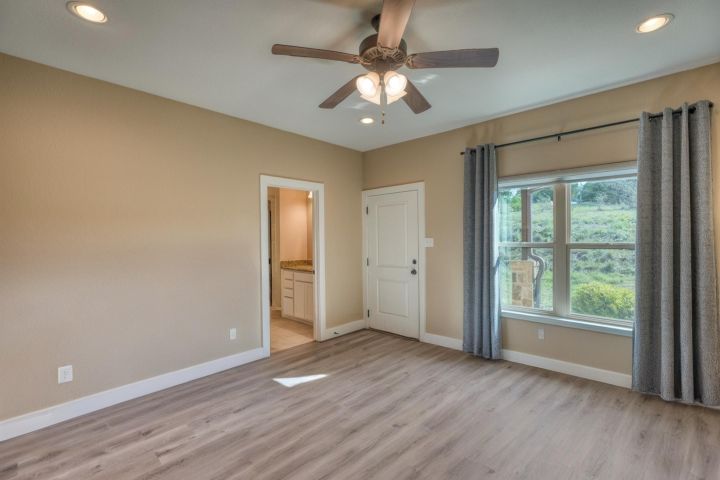 127 Uplift Horseshoe Bay, TX 78657 - Photo 12 of 35 Unfurnished bedroom featuring recessed lighting, light wood-type flooring, ceiling fan, and ensuite bathroom