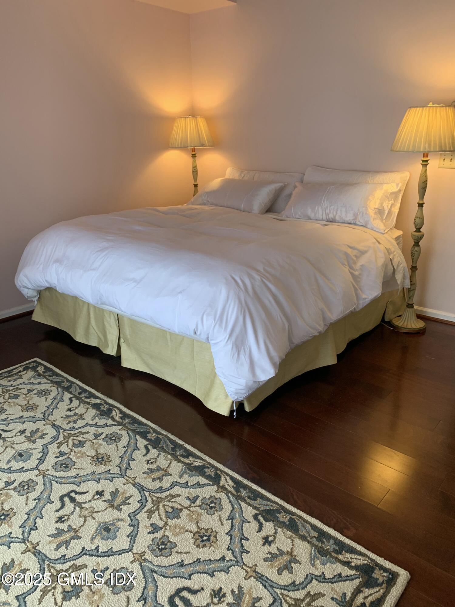 7 River Road, Unit 306 Cos Cob, CT 06807 - Photo 14 of 20 a bedroom with a bed and lamp with the rug