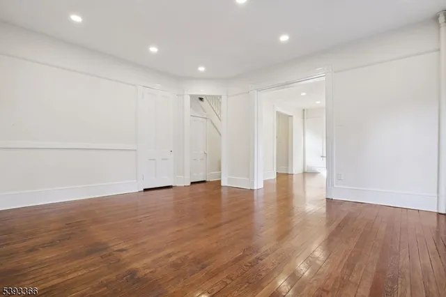 a view of empty room with wooden floor and window
