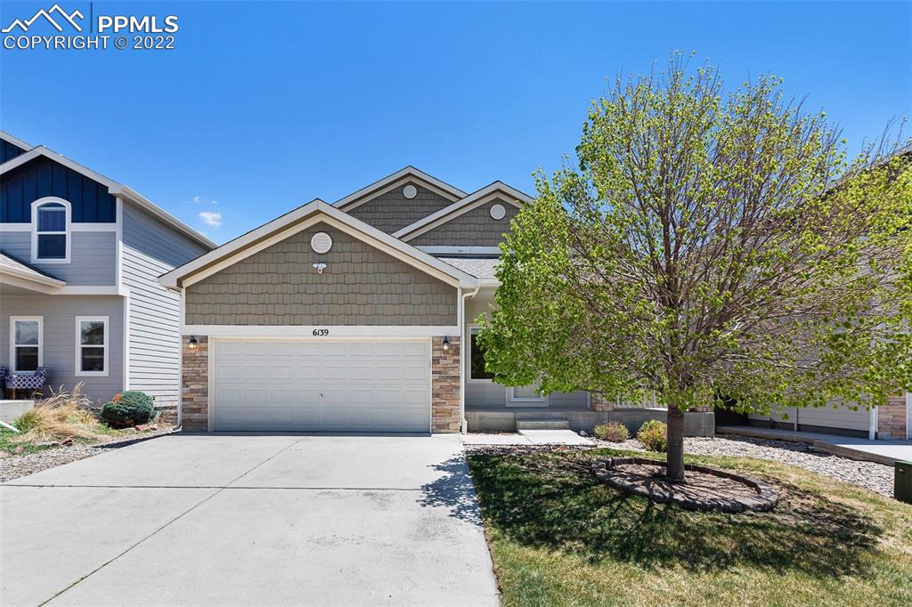 6139 Rocking Chair Lane Colorado Springs, CO 80925 - Photo 1 of 17 a front view of a house with a yard
