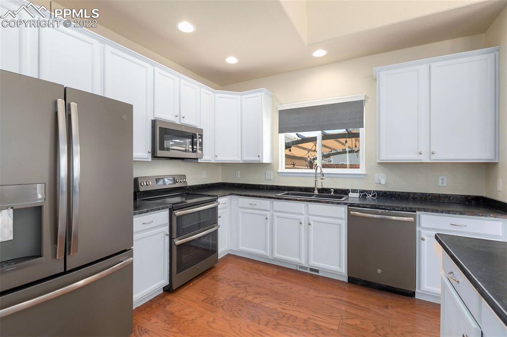 6139 Rocking Chair Lane Colorado Springs, CO 80925 - Photo 2 of 17 a kitchen with granite countertop a refrigerator stove and microwave