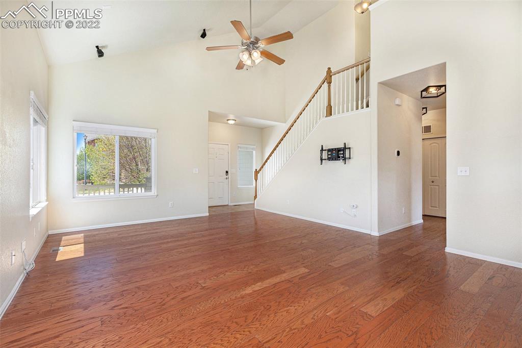 6139 Rocking Chair Lane Colorado Springs, CO 80925 - Photo 3 of 17 an empty room with wooden floor and windows