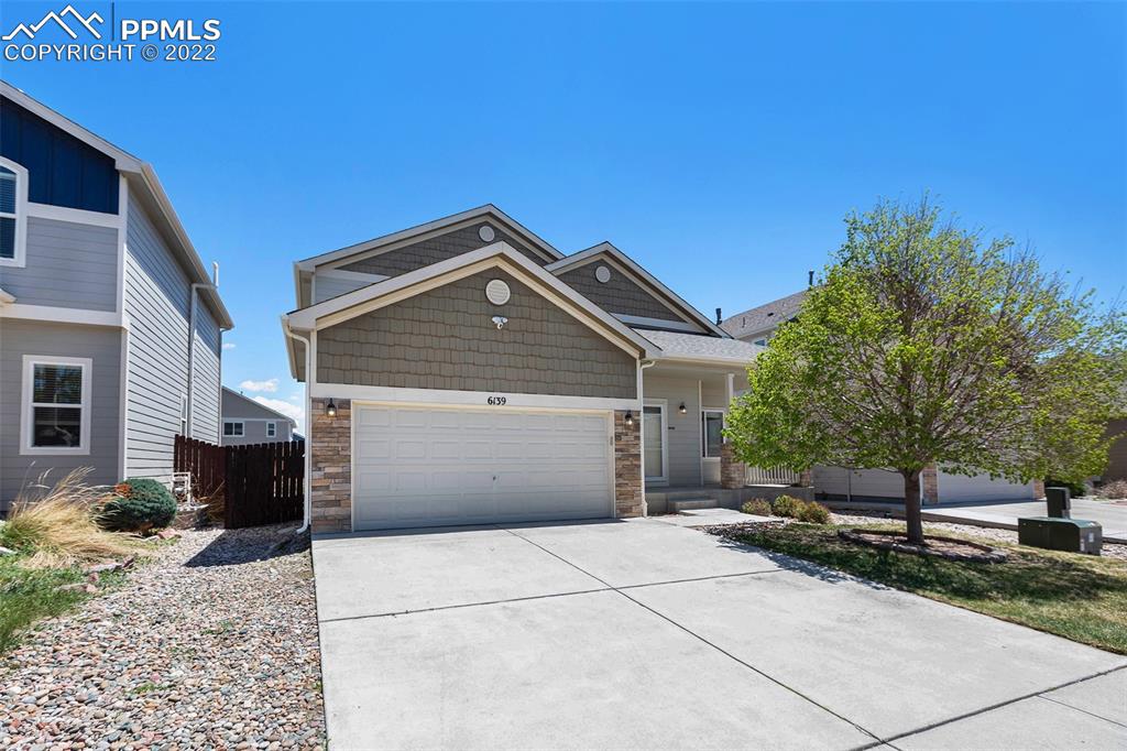 6139 Rocking Chair Lane Colorado Springs, CO 80925 - Photo 6 of 17 a front view of a house with a yard