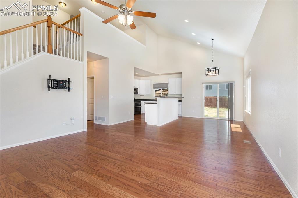 6139 Rocking Chair Lane Colorado Springs, CO 80925 - Photo 7 of 17 an empty room with wooden floor and windows
