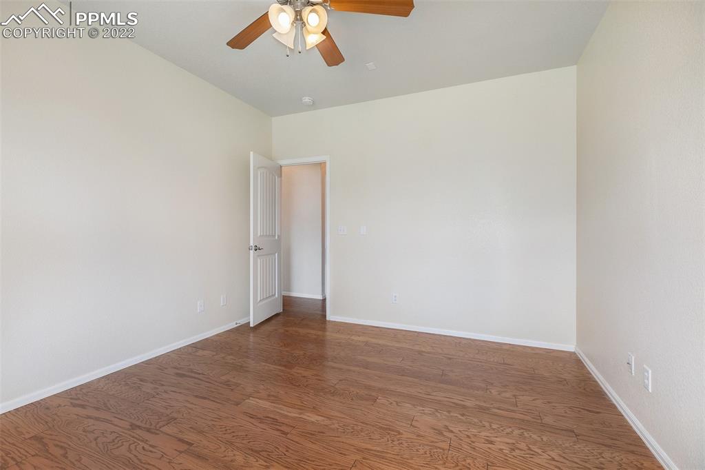 6139 Rocking Chair Lane Colorado Springs, CO 80925 - Photo 8 of 17 an empty room with wooden floor and fan