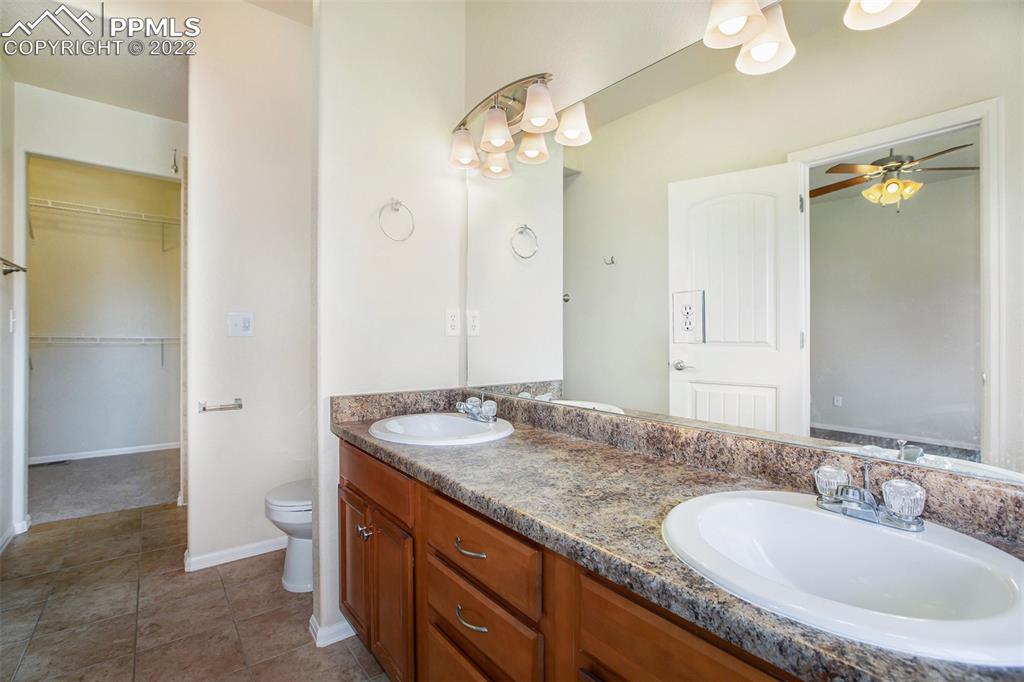 6139 Rocking Chair Lane Colorado Springs, CO 80925 - Photo 9 of 17 a bathroom with a granite countertop double vanity sink and a mirror