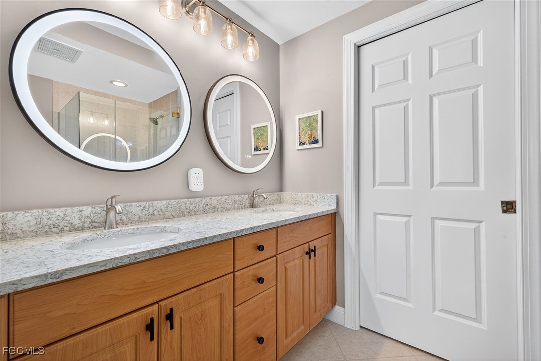 2743 First Street, Unit 701 Fort Myers, FL 33916 - Photo 19 of 31 a bathroom with a granite countertop double vanity sink and a mirror