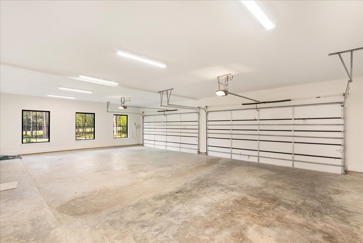 26041 Crown Ranch Boulevard Montgomery, TX 77316 - Photo 41 of 45 Oversized 18-foot-wide garage doors and approximately 25 feet of depth create a substantial, polished space designed to comfortably accommodate larger vehicles while adding Wi-Fi-enabled convenience, LED lighting, and estate-level functionality.