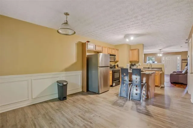 a kitchen with refrigerator and chairs