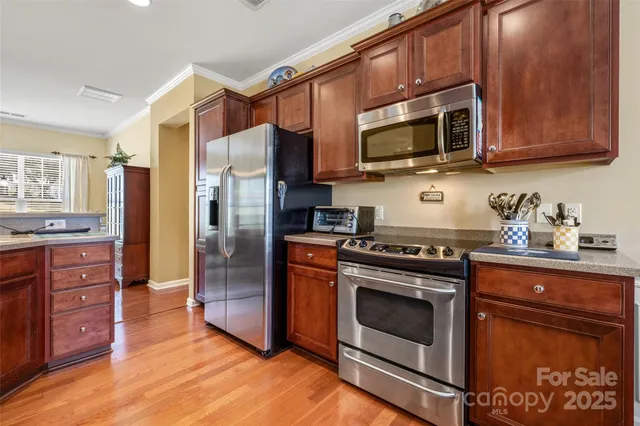 a kitchen with stainless steel appliances granite countertop a stove microwave refrigerator and cabinets