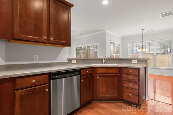 a kitchen with stainless steel appliances granite countertop wooden cabinets and a sink