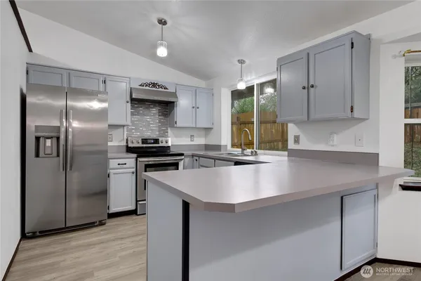 a kitchen with stainless steel appliances granite countertop a sink stove and refrigerator