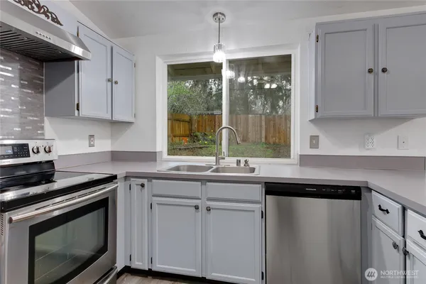 a kitchen with a sink stove and cabinets