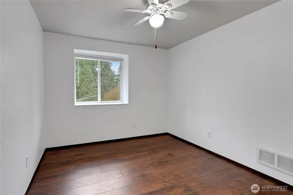 an empty room with a window and a fan