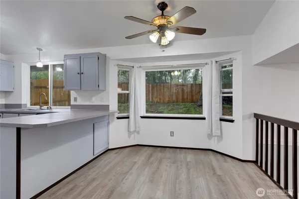 a view of an empty room with a kitchen and a sink