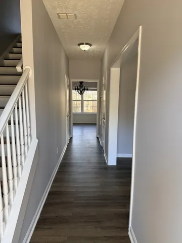 a view of a hallway with wooden floor