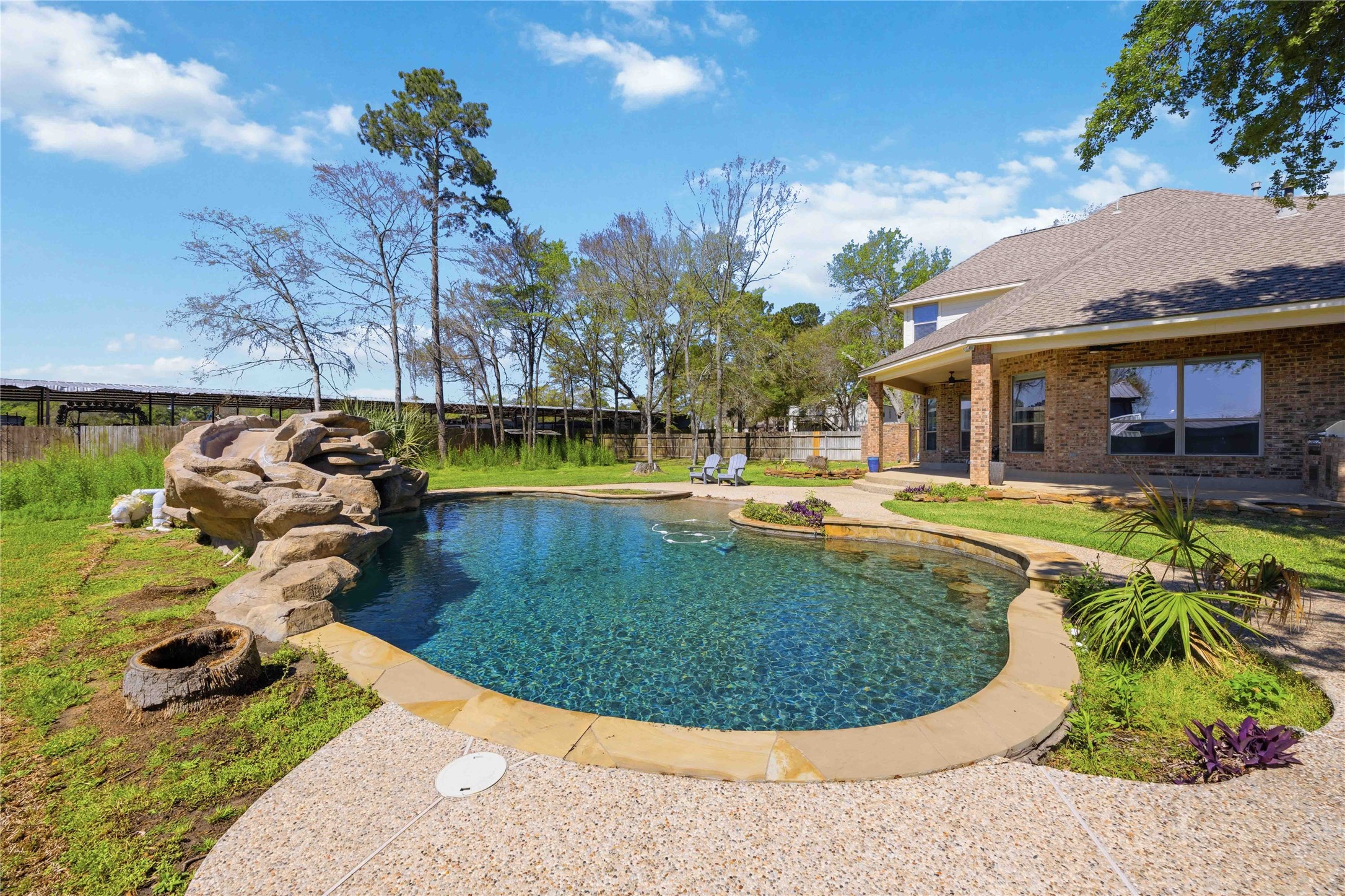 1930 Old River Road Montgomery, TX 77356 - Photo 35 of 49 Look at that glistening pool! Surrounded by landscaping and a stone grotto with a built-in slide, this looks like the backdrop for hours of fun!