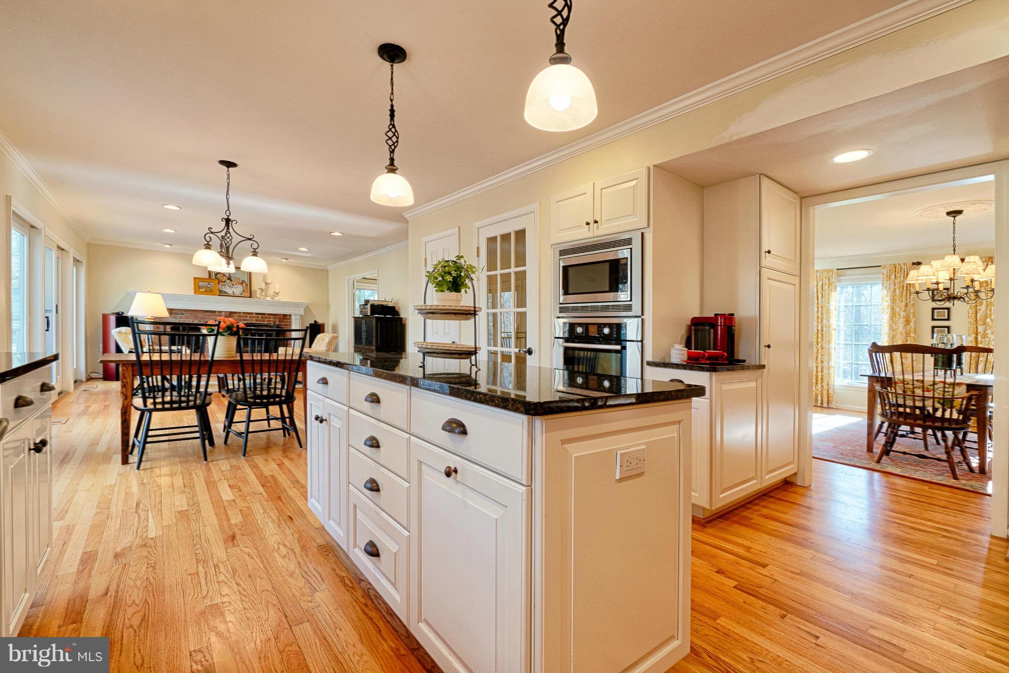 11008 Raccoon Ridge Court Reston, VA 20191 - Photo 11 of 30 a kitchen with stainless steel appliances kitchen island granite countertop a stove a refrigerator a kitchen island a dining table and chairs with wooden floor