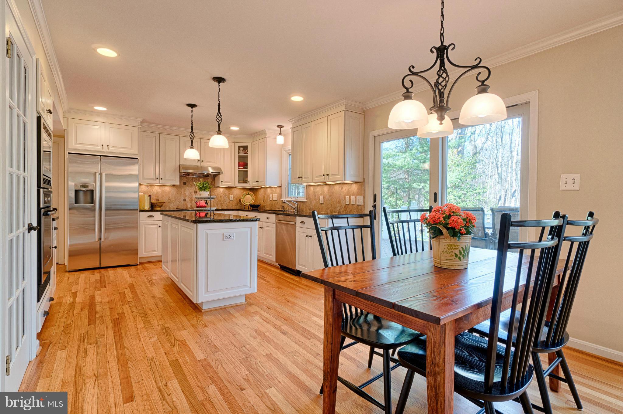 11008 Raccoon Ridge Court Reston, VA 20191 - Photo 9 of 30 a kitchen with stainless steel appliances granite countertop a dining table chairs and wooden floor