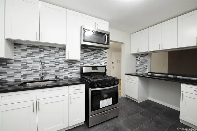 a kitchen with stainless steel appliances granite countertop a stove and a microwave