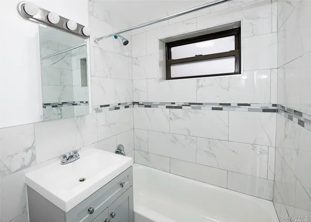 a bathroom with a bathtub sink and mirror