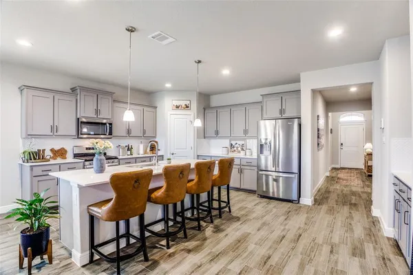 a kitchen with refrigerator and chairs
