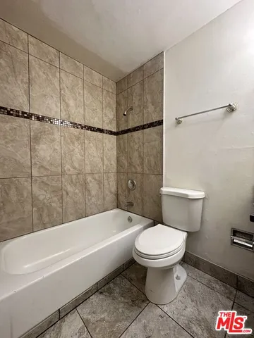 a white toilet sitting next to a bath tub and shower
