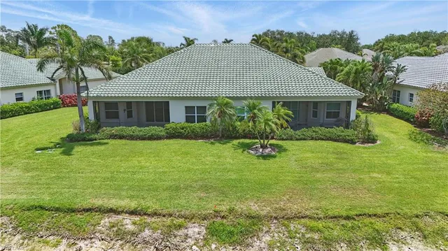 an aerial view of a house with a yard and lake view