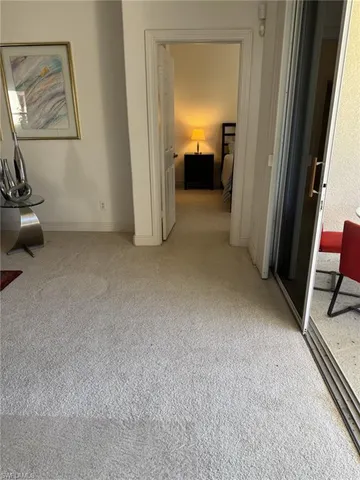 a spacious bedroom with a bed and a lamp