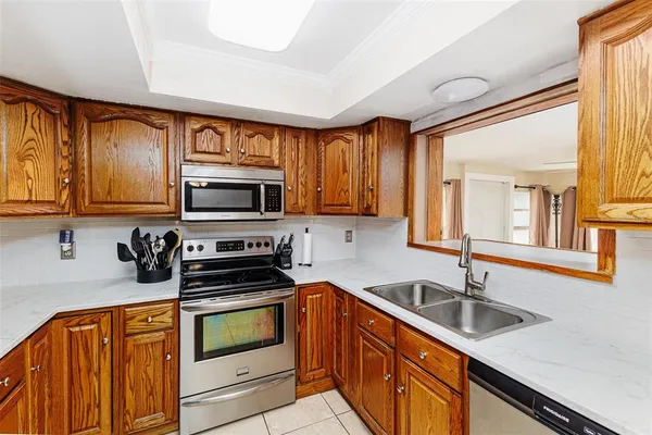 a kitchen with granite countertop a sink stainless steel appliances and cabinets