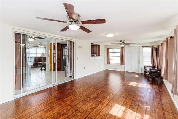 a view of a livingroom with wooden floor and a ceiling fan
