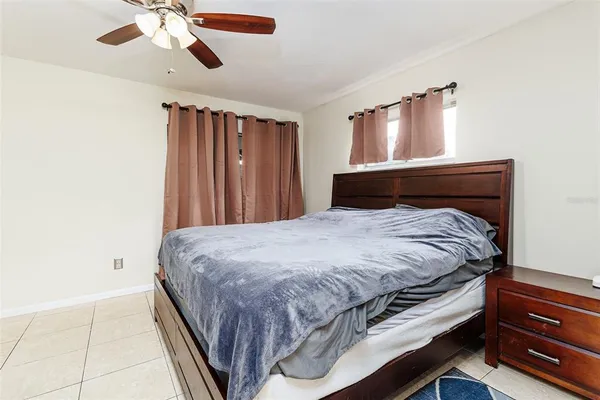 a bedroom with a bed and a ceiling fan