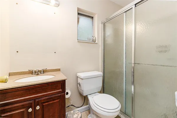 a bathroom with a sink a toilet a shower and a mirror