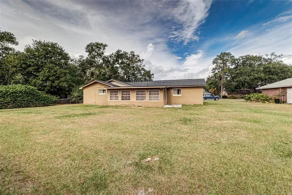 a front view of house with yard and trees in the background