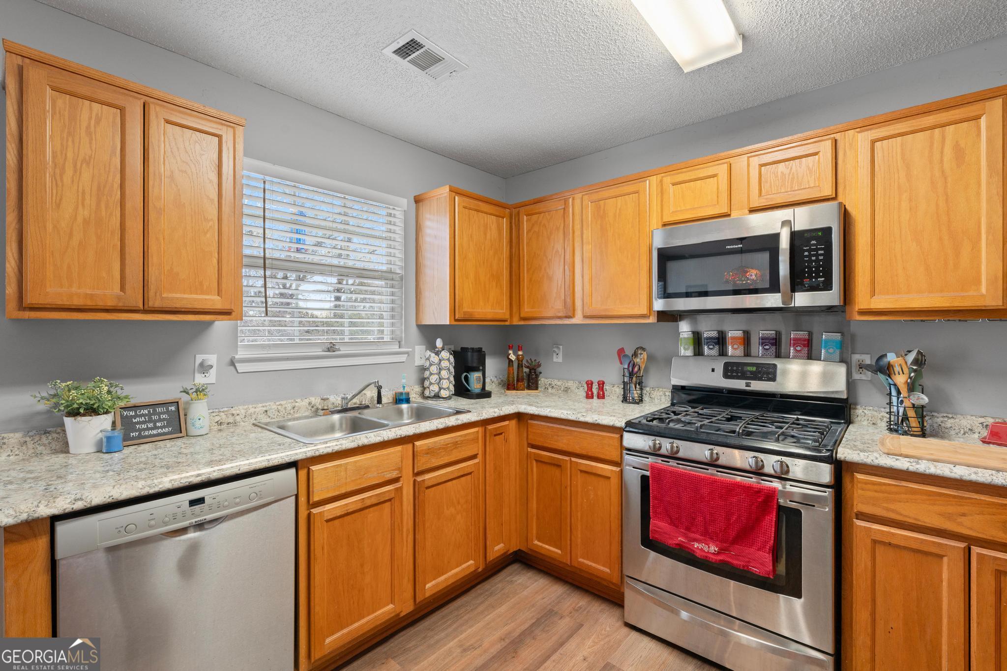 340 Harris Avenue Locust Grove, GA 30248 - Photo 15 of 41 a kitchen with stainless steel appliances granite countertop a stove sink microwave and window
