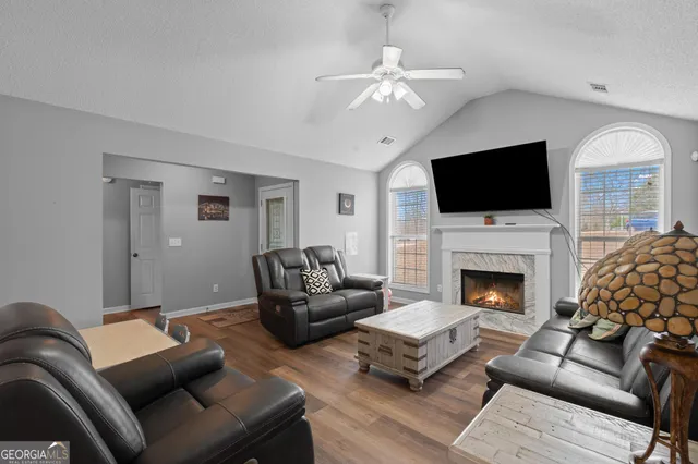 a living room with furniture and a wooden floor