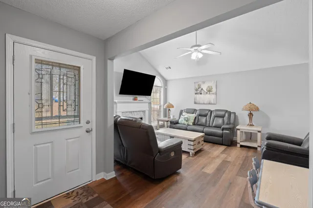 a living room with furniture a flat screen tv and a fireplace
