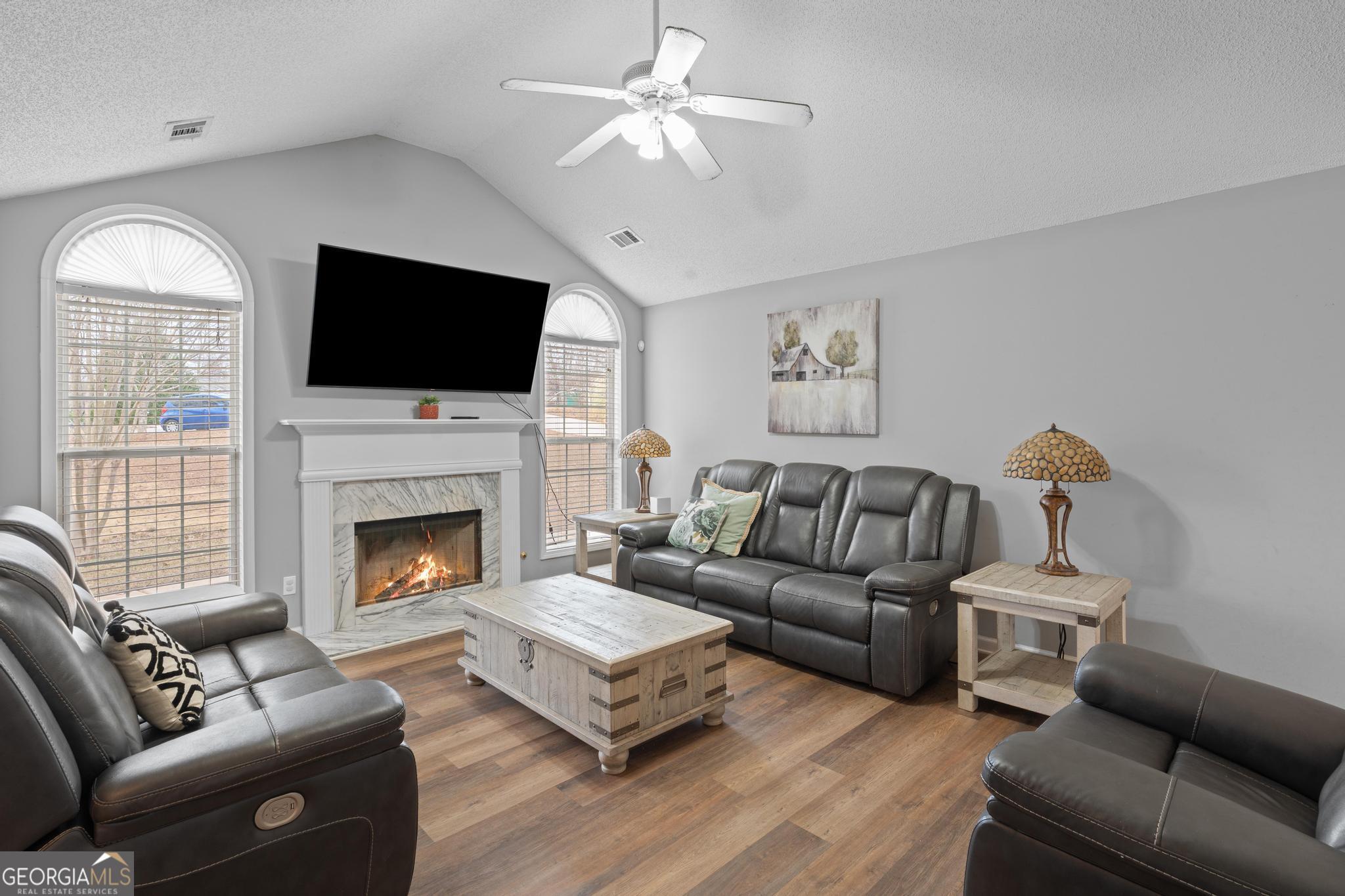 340 Harris Avenue Locust Grove, GA 30248 - Photo 8 of 41 a living room with furniture a flat screen tv and a fireplace