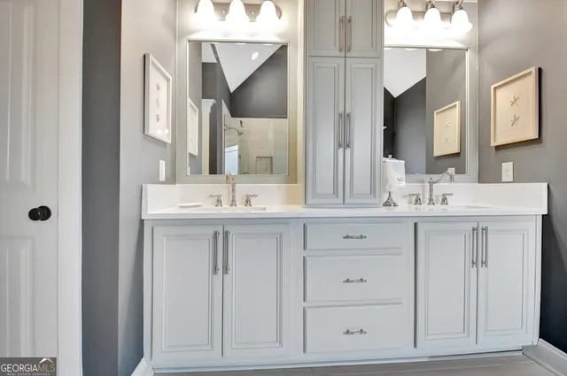 a spacious bathroom with double vanity a large mirror and a bathtub