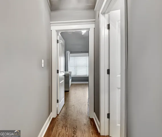 a view of staircase with wooden floor and white walls